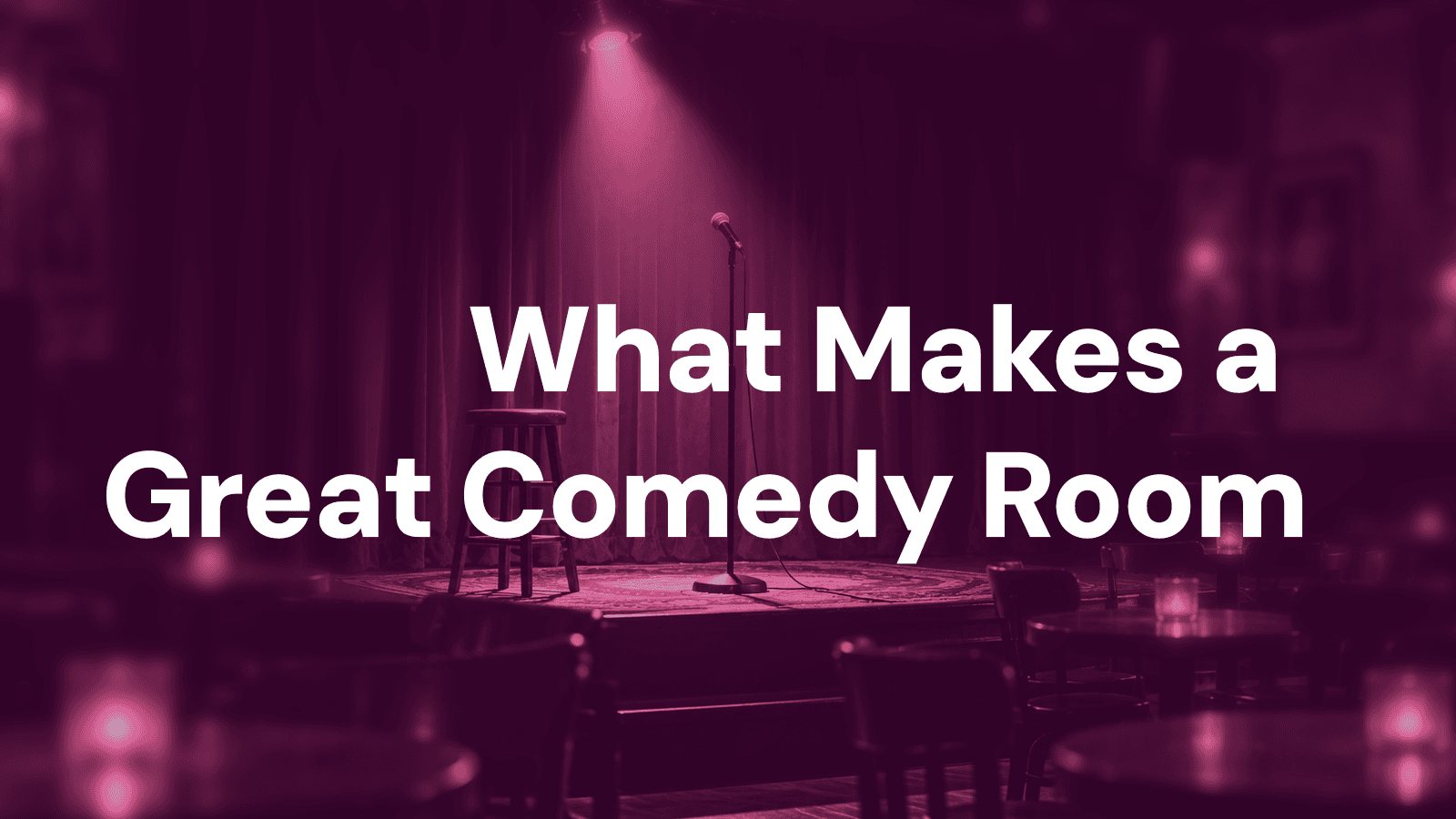 A dimly lit, empty comedy club stage with a single spotlight and a microphone